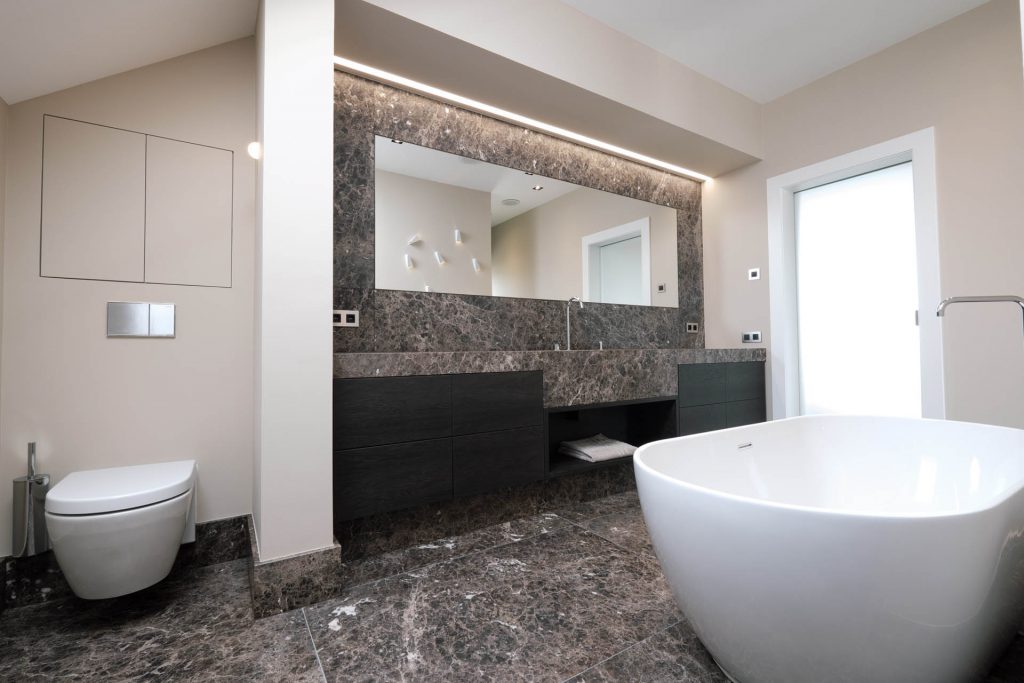 Badezimmer mit freistehender Badewanne und Bodenfliesen aus Naturstein