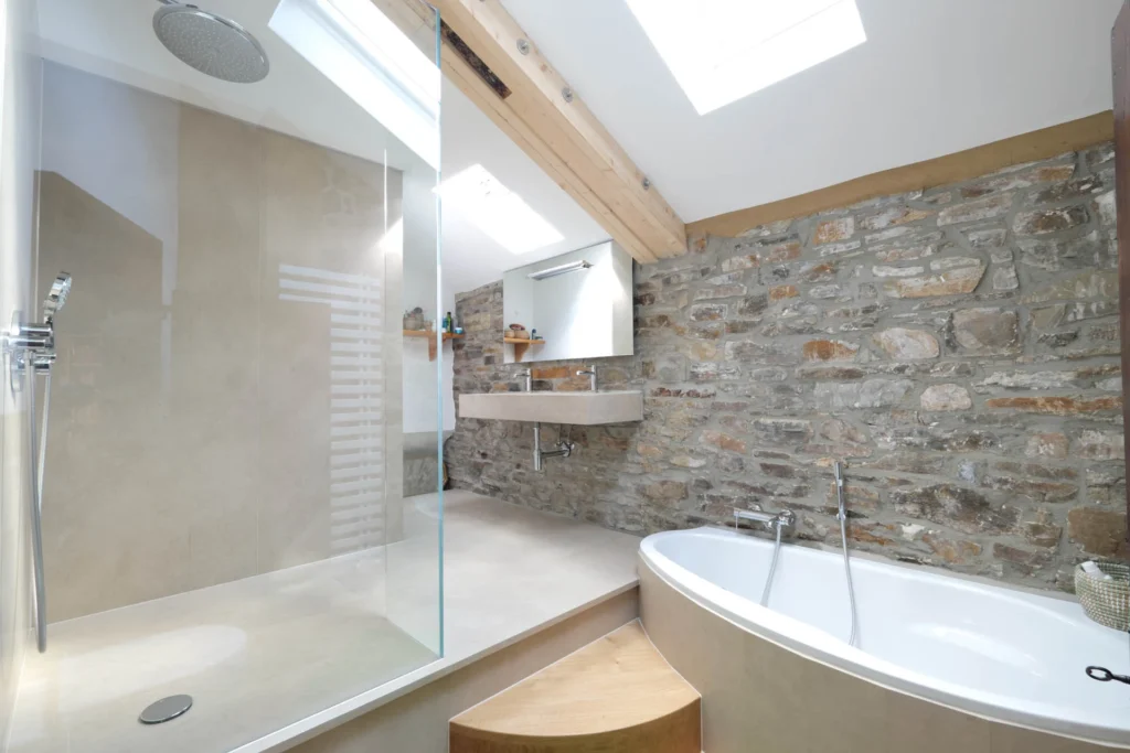Badezimmer mit rustikaler Steinwand und Natursteindusche