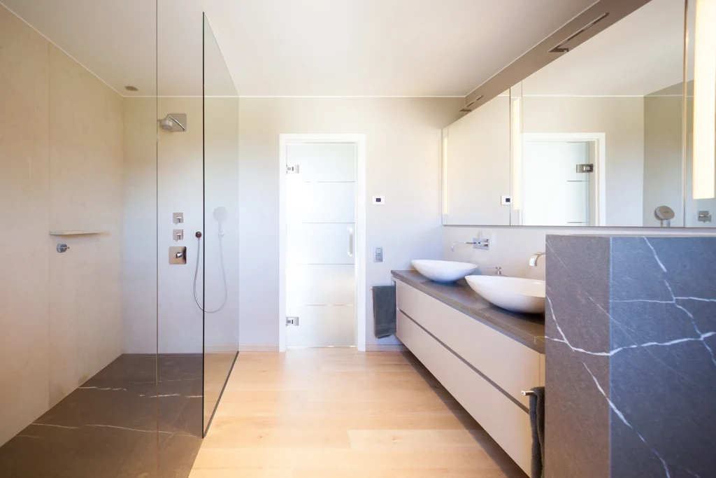 Badezimmer mit Holzboden und grauen Naturstein-Verkleidungen