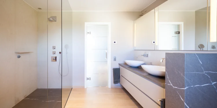 Badezimmer mit Holzboden und grauen Naturstein-Verkleidungen