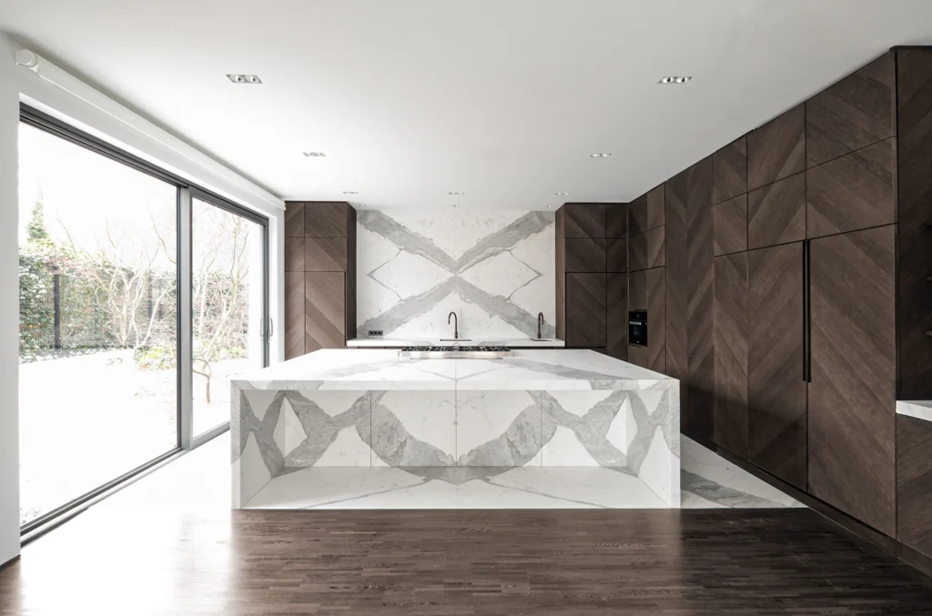 Küche mit Kücheninsel und gespiegelter Rückwand aus Naturstein Statuario