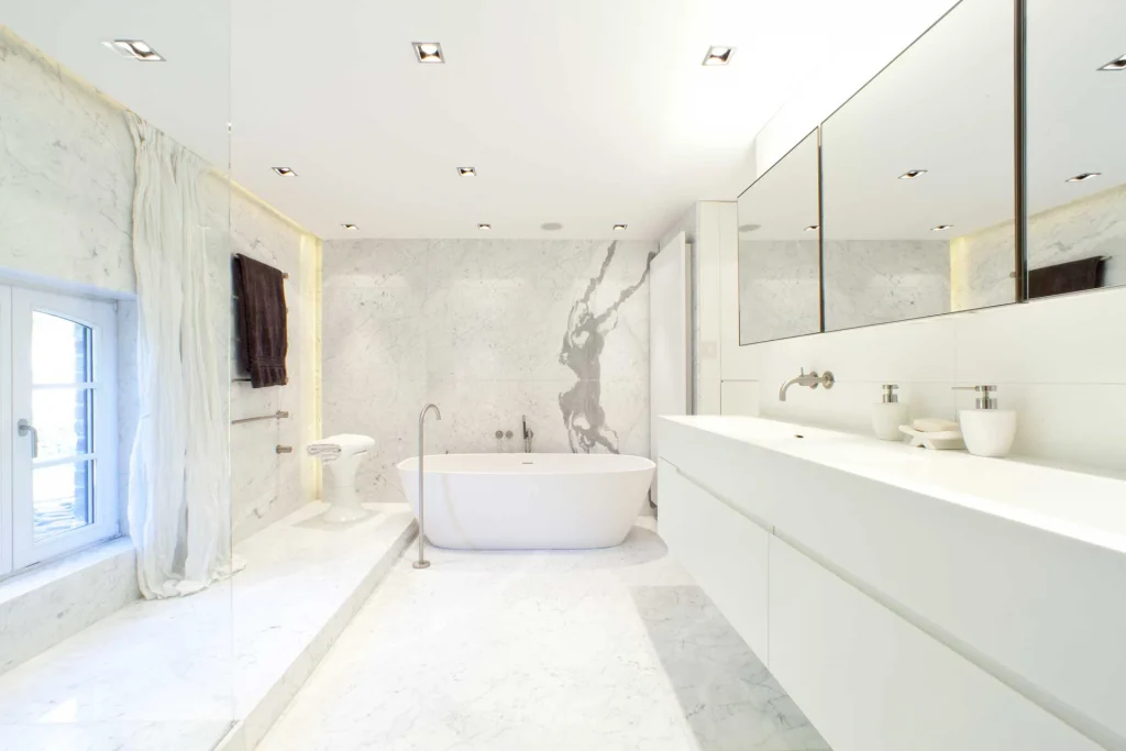 Badezimmer mit weißem Marmor und Vola Armaturen